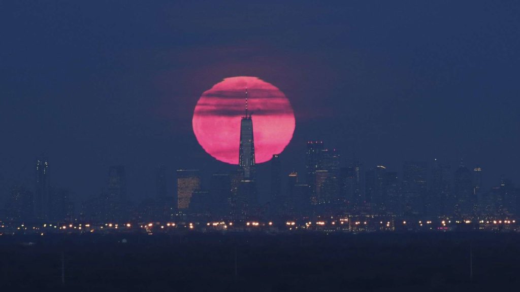 The super snow moon (called as such for appearing in winter) is rising behind the iconic coastline of Manhattan in New York City.