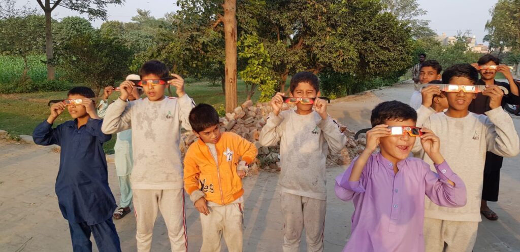 Kids from the Zaawiya Trust School watching the event safely through solar viewers/glasses. The Kainaat Studio arranged the session, which has also started Astronomy Clubs in Lahore, Pakistan, to educate and encourage students about the field of Astronomy. (Image Credit: Prof. Dr. Salman Hameed - Founder Kainaat Studious & Professor of Astronomy at the Hampshire College).  