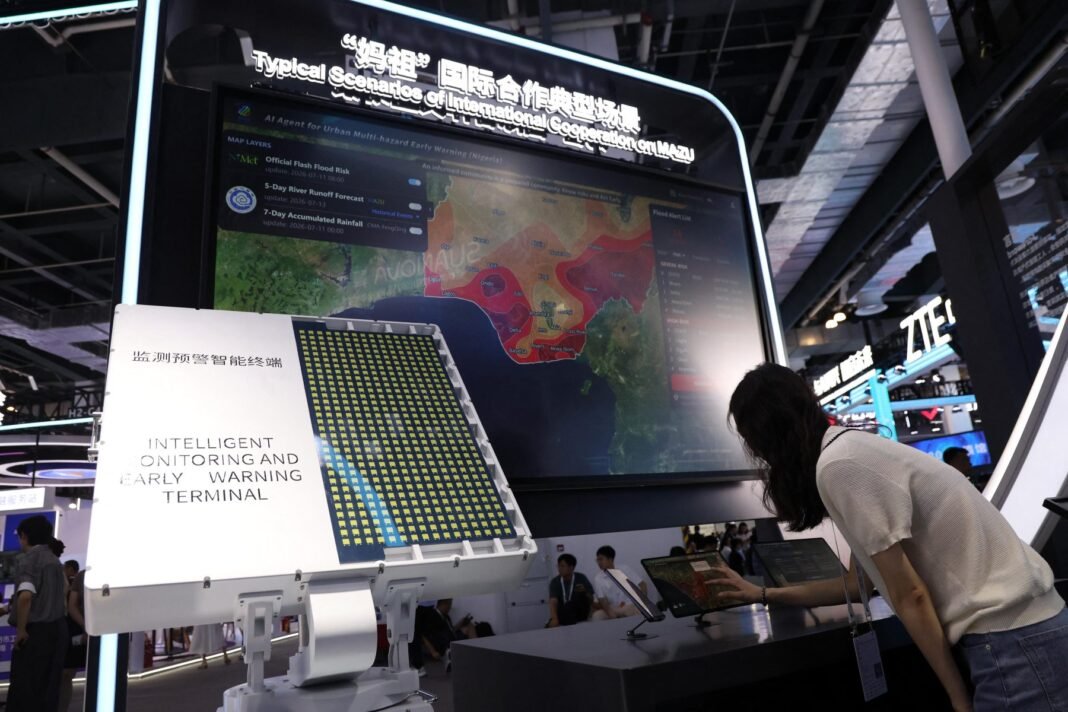 An attendee interacts with Chinese AI system MAZU – short for “multi-hazard, alert, zero-gap and universal” – at the 2026 World Artificial Intelligence Conference in Shanghai, July 2026 (Image: Sipa US / Alamy)